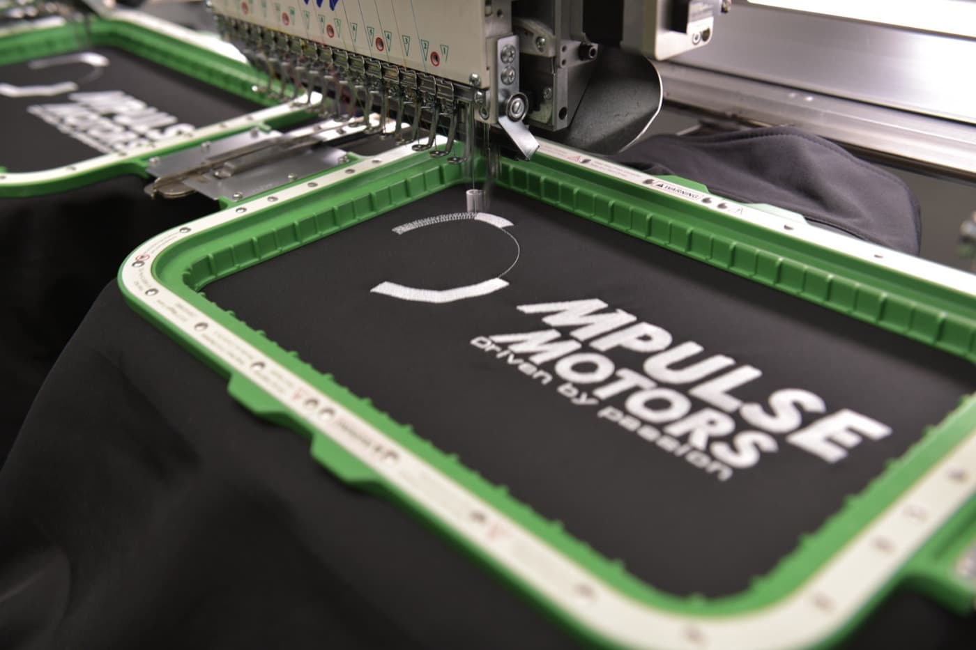 Professional embroidery machine stitching a logo onto workwear